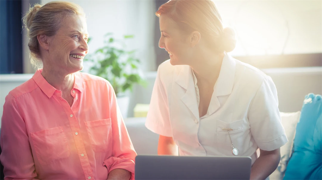 Kvinnlig sjuksköterska i samtal med kvinnlig patient