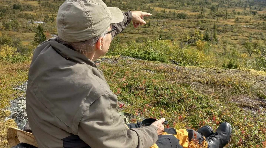 En man som pekar utöver en dalgång