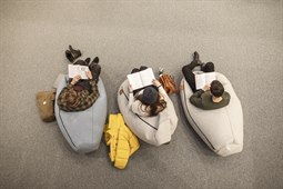 Läser bok sittande i mysiga säckar