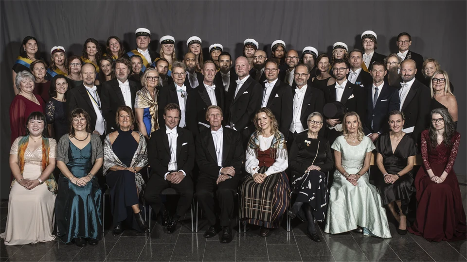 A group photo of just over fifty well-dressed people.