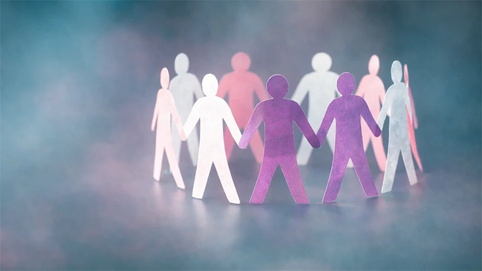 Pappersfigurer i ring som håller varandra i hand.