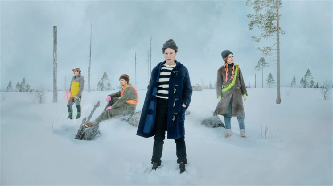 Fyra personer står på ett snöklätt kalhygge