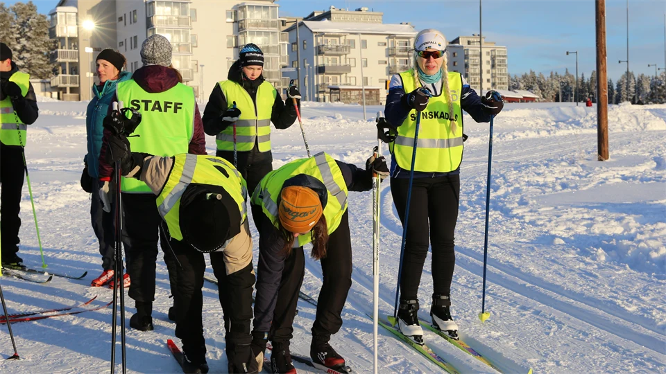 Skidåkare med reflexvästar i skidspår.