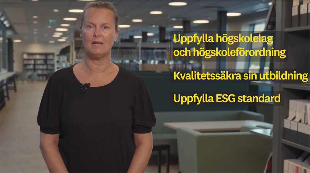 Kvinna med ljust uppsatt hår ståendes i ett kontorslandskap.