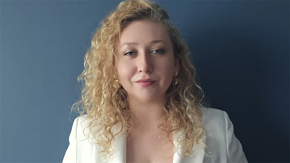 Ung kvinna klädd i vitt mot mörk bakgrund