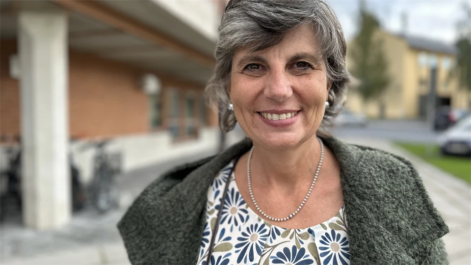 Kvinna i jacka utanför byggnad