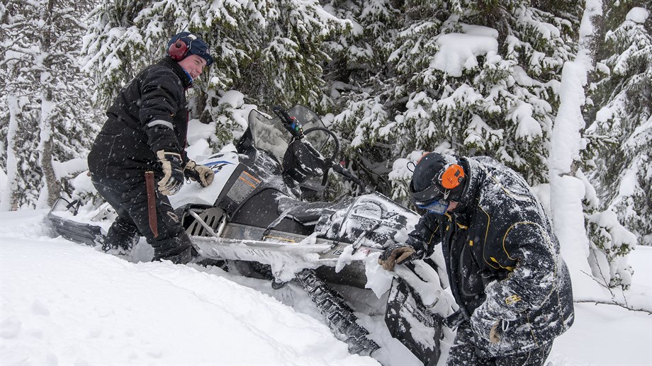 Jåvva Stenfjell och Bengt Åke Jåma lyfter loss skotern.