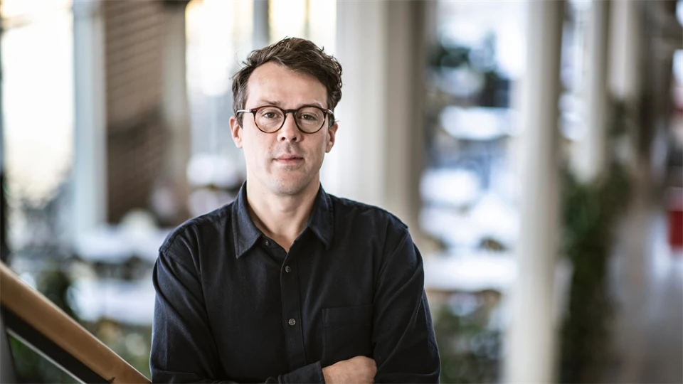 Manlig forskare ståendes i trappa i byggnad på Mittuniversitetets campus i Östersund