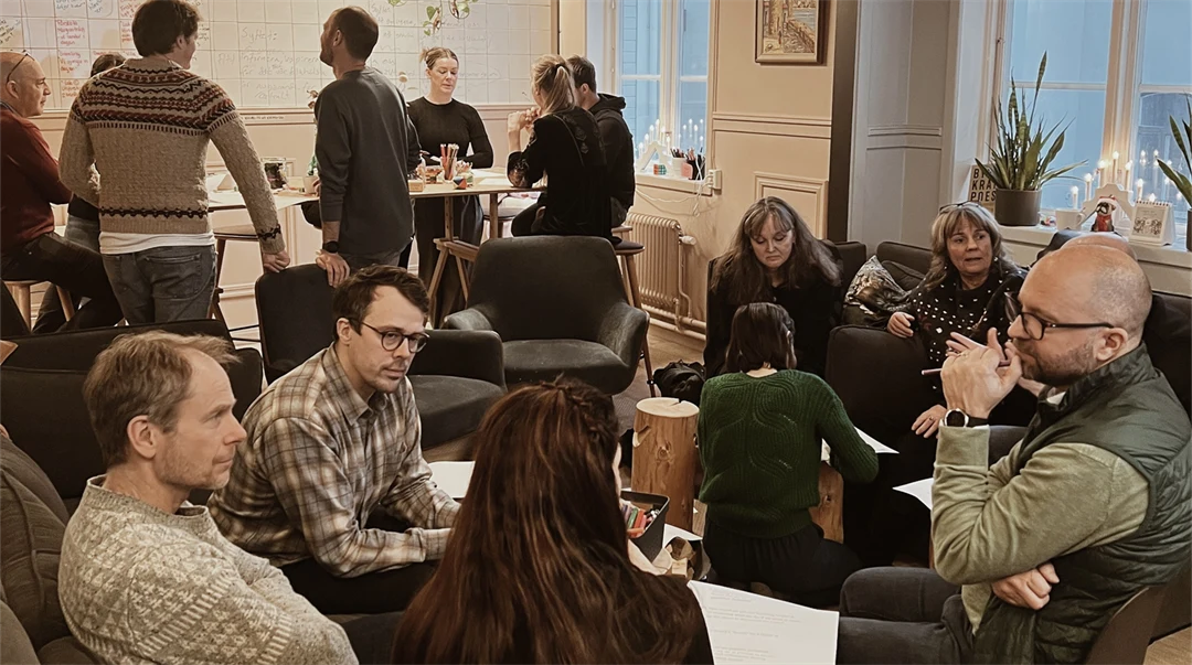 Ett tiotal kollegor sitter och pratar med varandra i ett informellt konferensrum