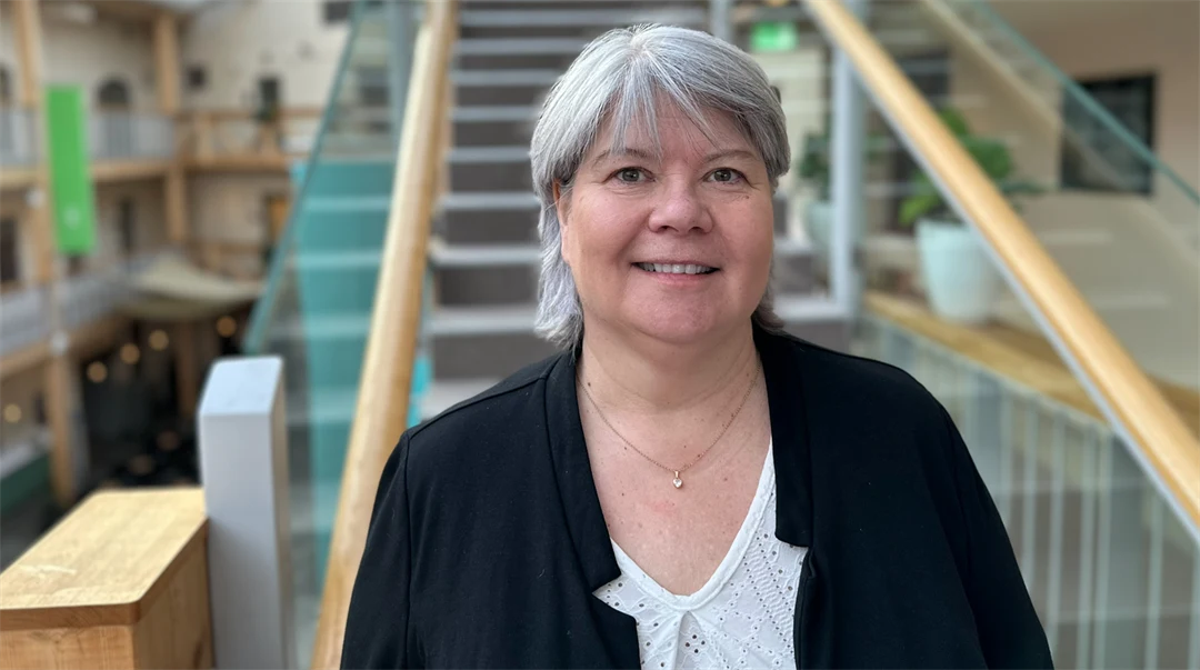 Porträttfoto av en kvinna med grått hår och en svart kavaj