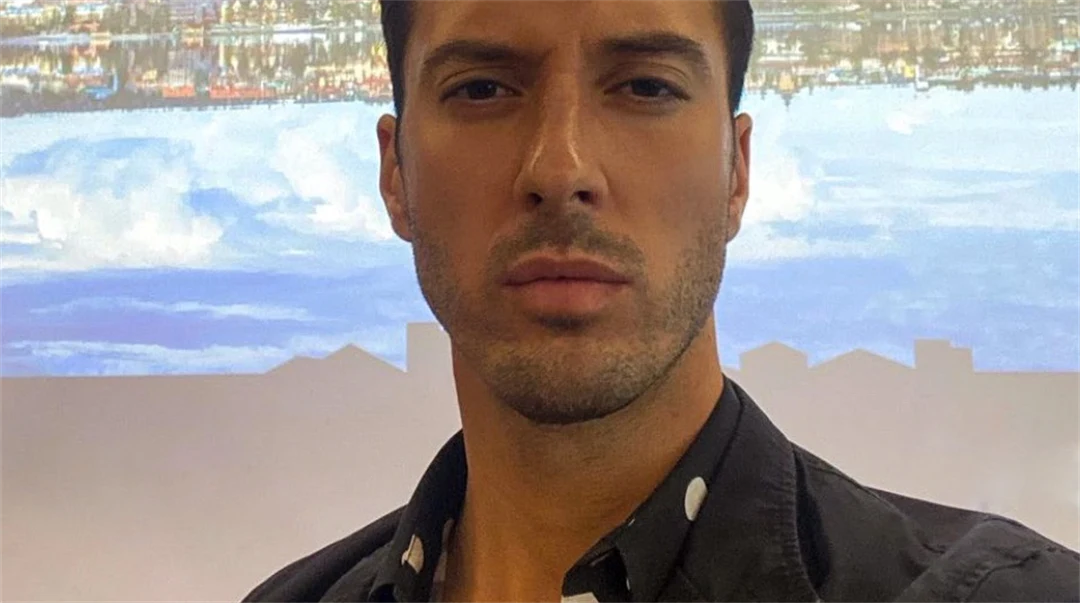 A portrait photo of a man with short dark hair