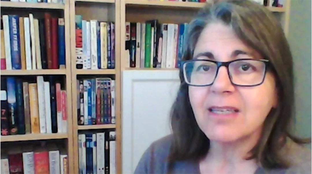 Kvinna framför bokhylla.