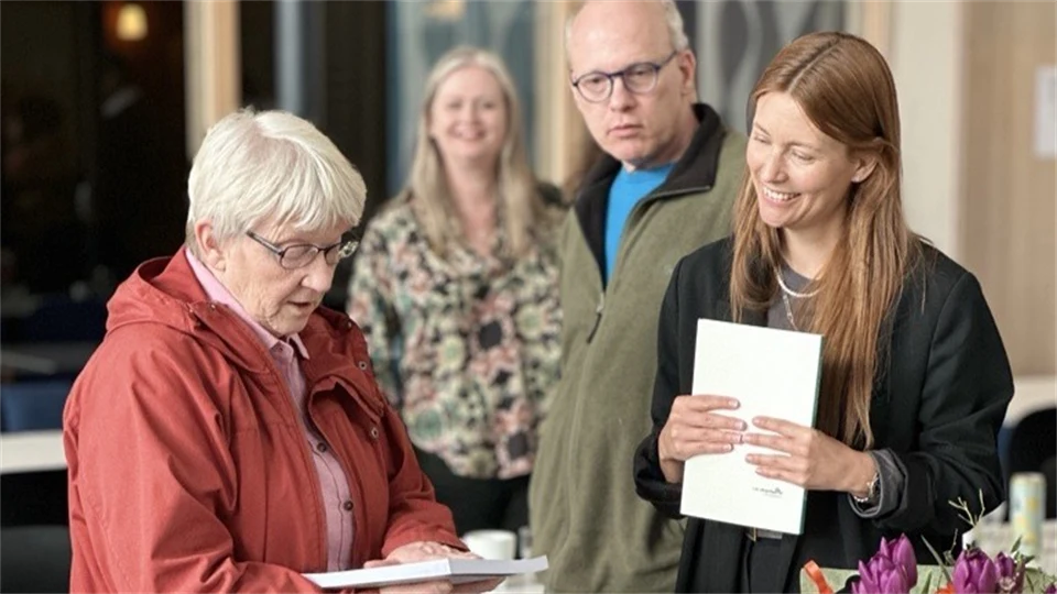 Two women, one older and one younger, stand opposite each other and talk. 