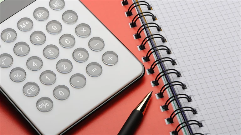  A calculator and a pen lie on a notebook.