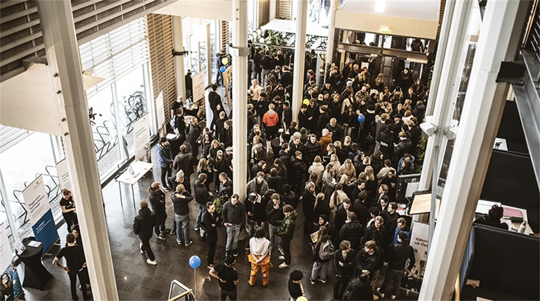 En stor grupp elever står på insidan av ingången till Ljushallen. 