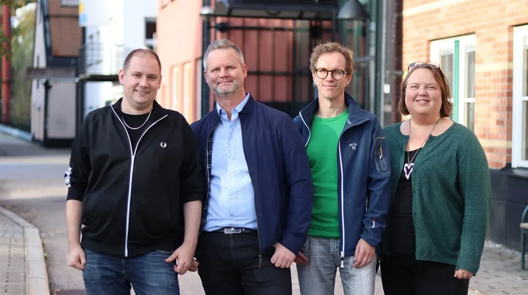 Fyra personer står framför en byggnadl