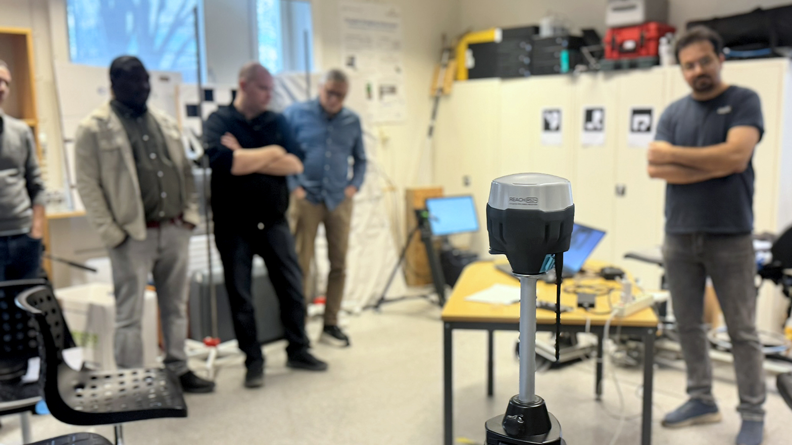 A measurement tool with people standing in the background.