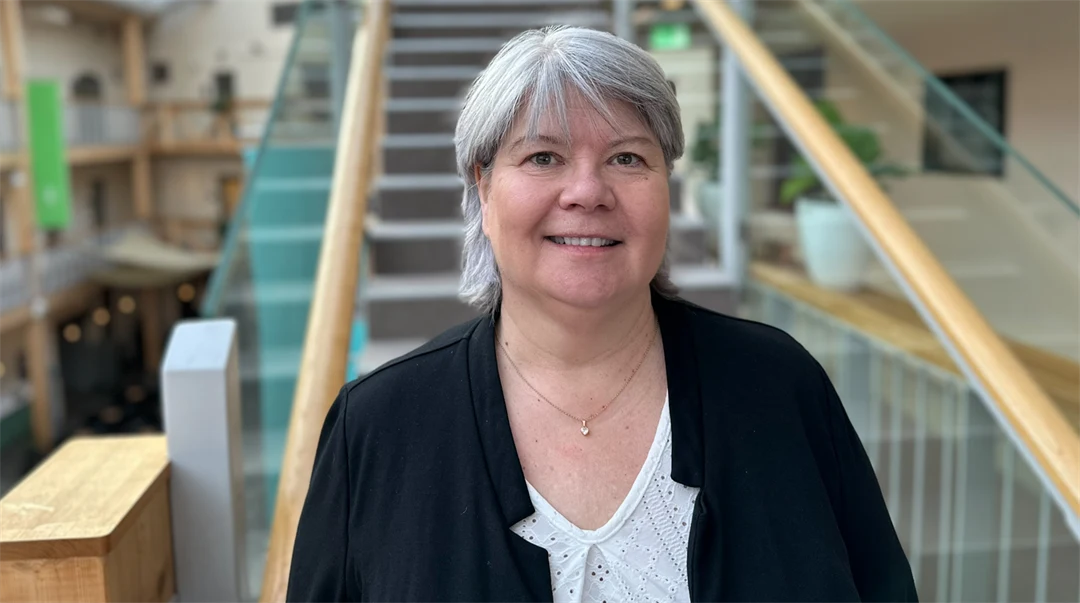 A portrait photo of a woman in gray hair and a black jacket