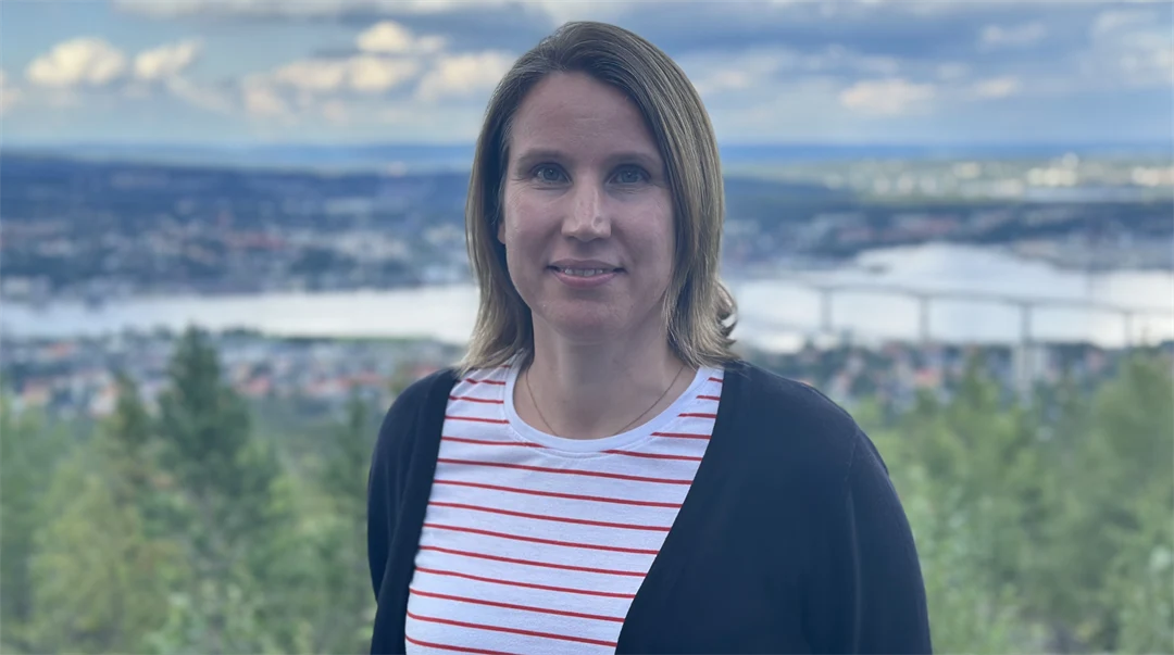 Kvinna med brunt hår och en röd/vit-randing tröja