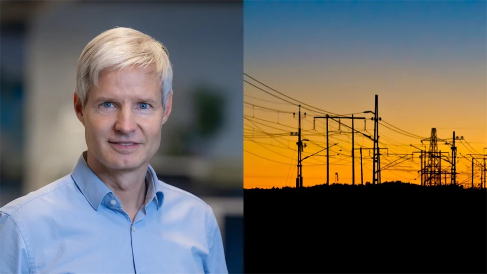 En man med ljust hår och blå skjorta bredvid en bild som visar en solnedgång bakom elstolpar