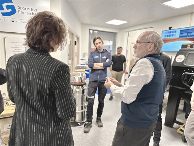 People engaged in conversation in a lab environment.