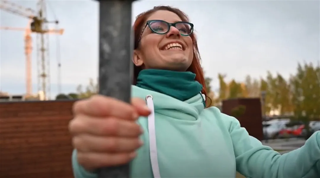 Glad kvinna som tränar i utegym.