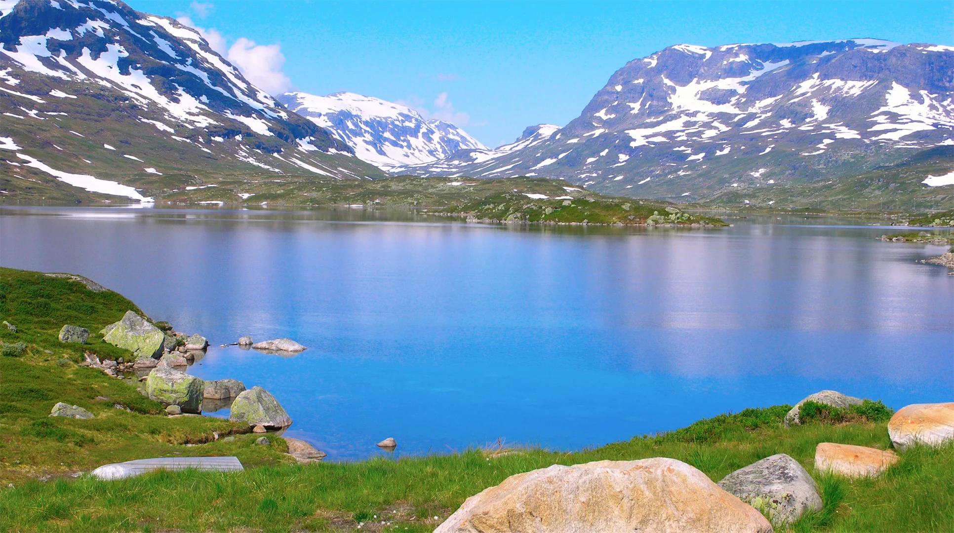 Norska fjäll med en tjärn i förgrunden
