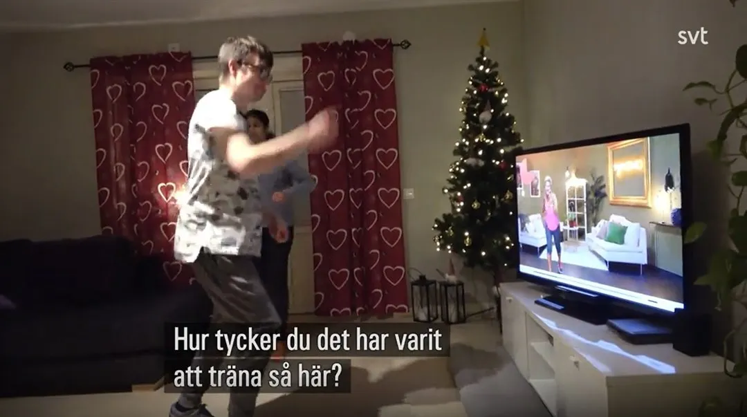 Bild på två personer som tränar framför en skärm med ett träningsprogram på.