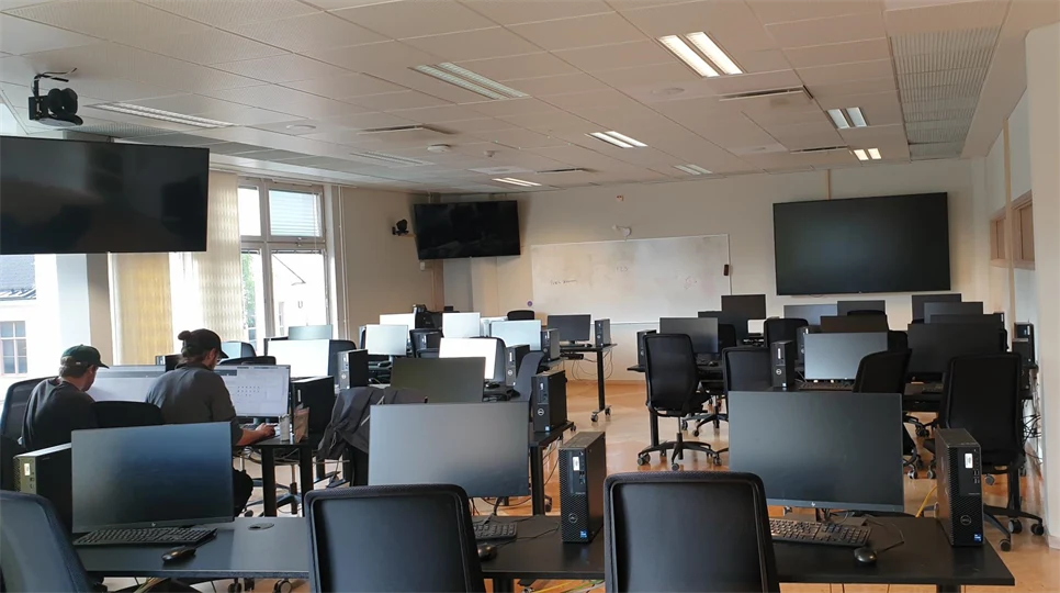 Sal med dataskärmar och bord, stolar, bildskärmar