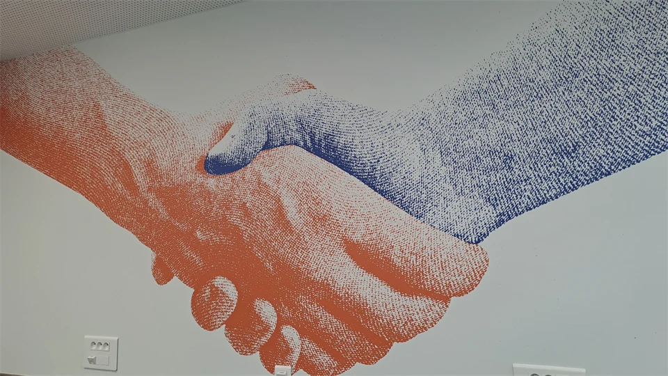 Handshake with two digital hands in different colours.