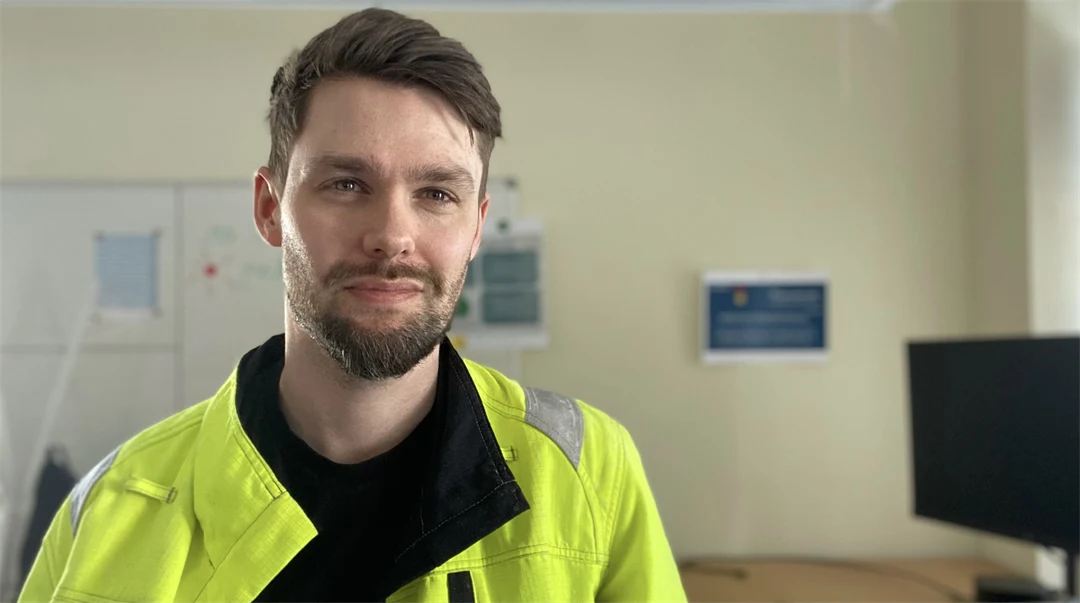 En man på ett kontor tittar in i kameran.