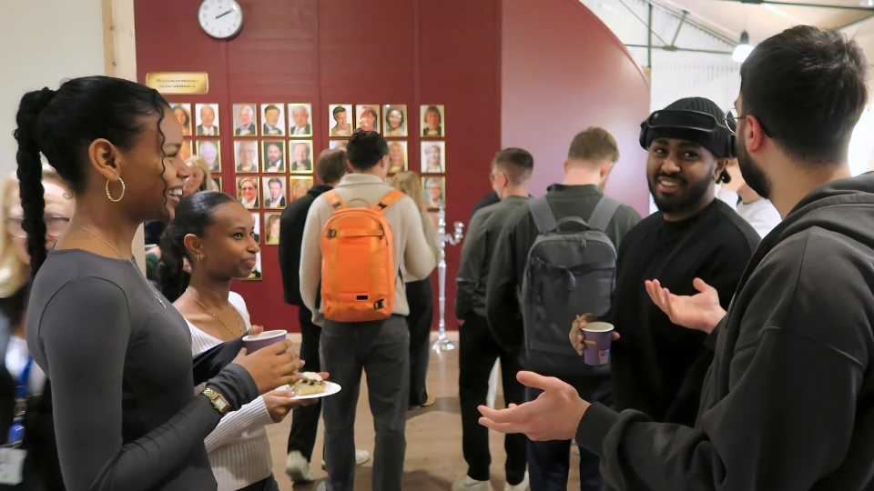 Grupp av studenter som samtalar med varandra under fikapaus