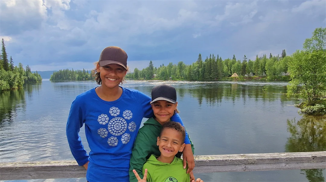 Tre barn på en bro över en älv