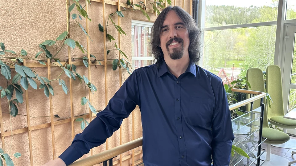 A man with a blue shirt and long brown hair