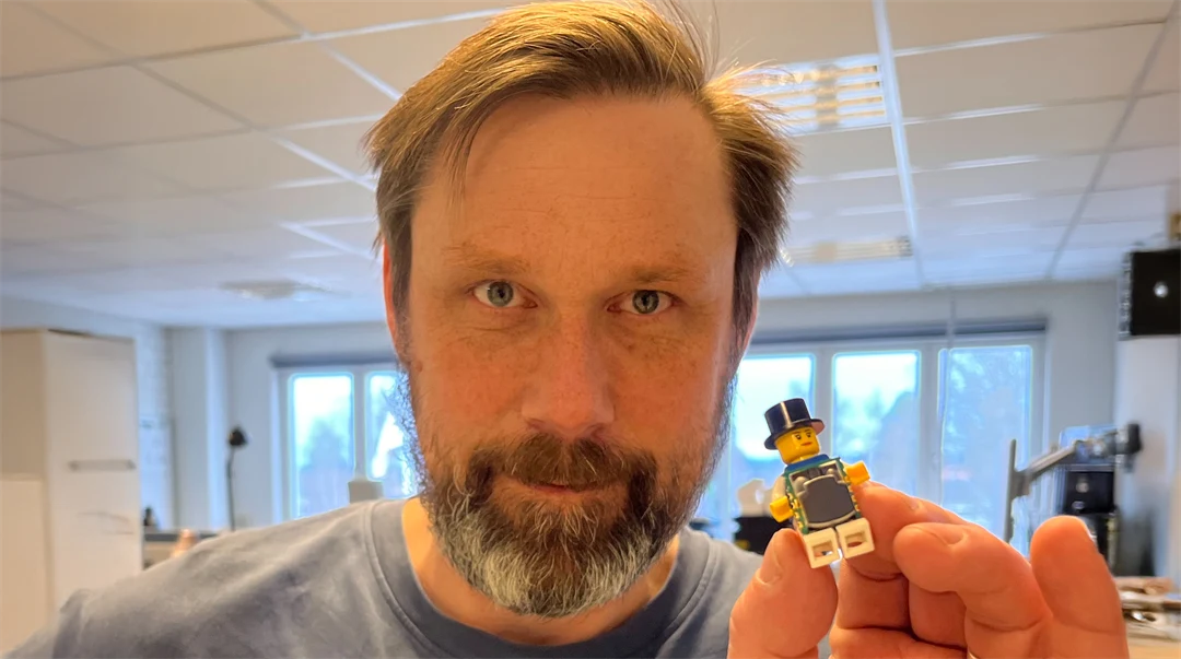 En man håller i en legofigur.