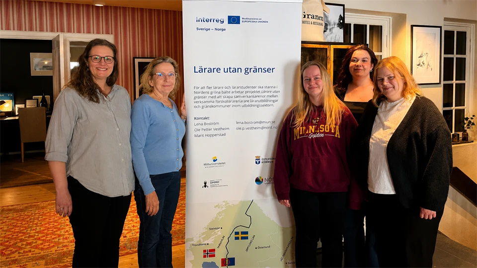 Gruppbild fem kvinnor framför en rollup.