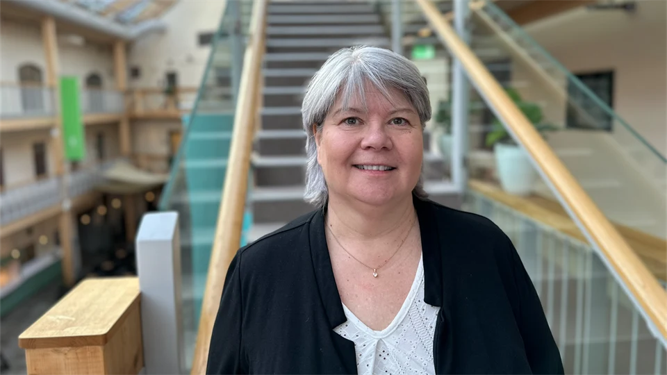 Porträttfoto av en kvinna med grått hår och en svart kavaj