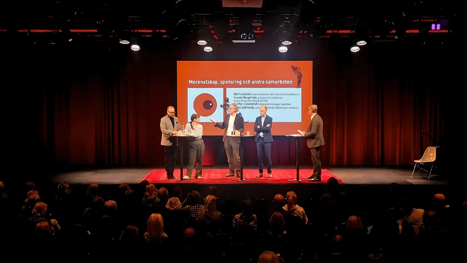 Fem talare står på en scen under evenemanget