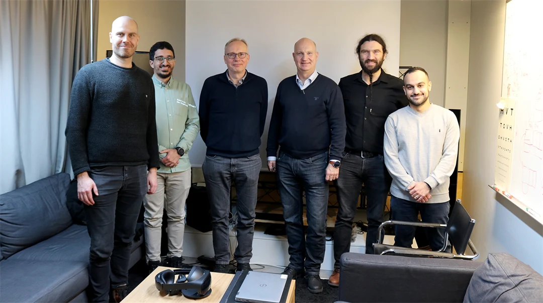 Six men stands up towards the camera an smiles. 