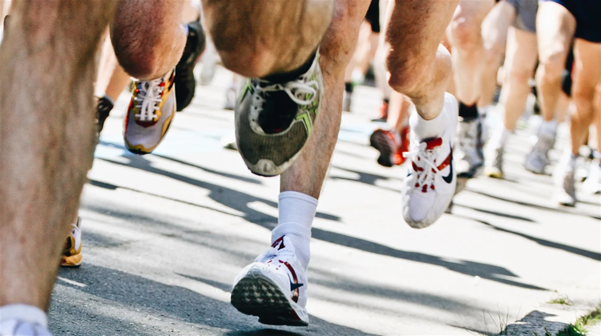 Massor av ben springer på asfalt under ett maraton