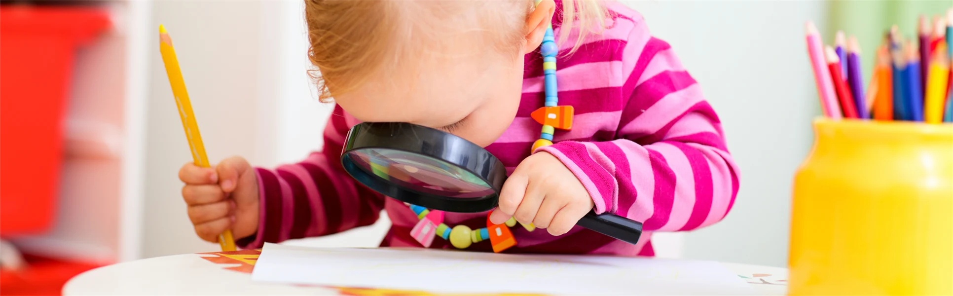 Förskolebarn tittar i förstoringsglas