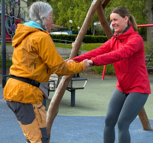 Två kvinnor håller varandras händer och balanserar