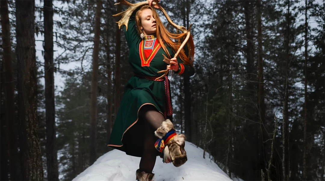 En kvinna i grön kolt som dansar på en snöhög