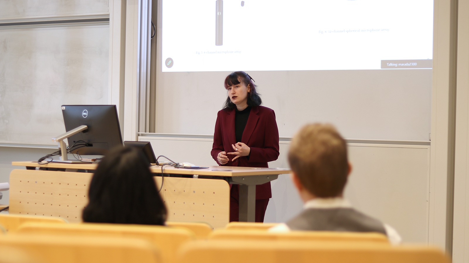 a women standing in front of a crowd and present