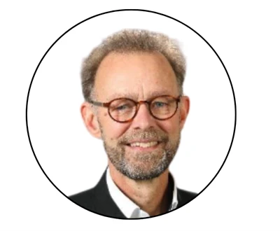 En man med skägg och runda glasögon.