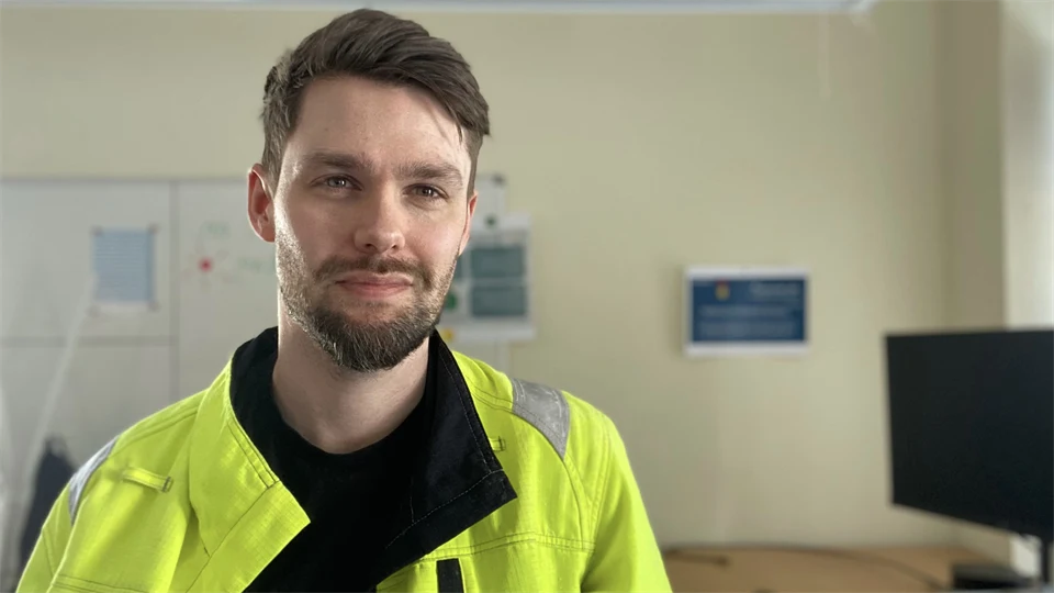 En man på ett kontor tittar in i kameran.