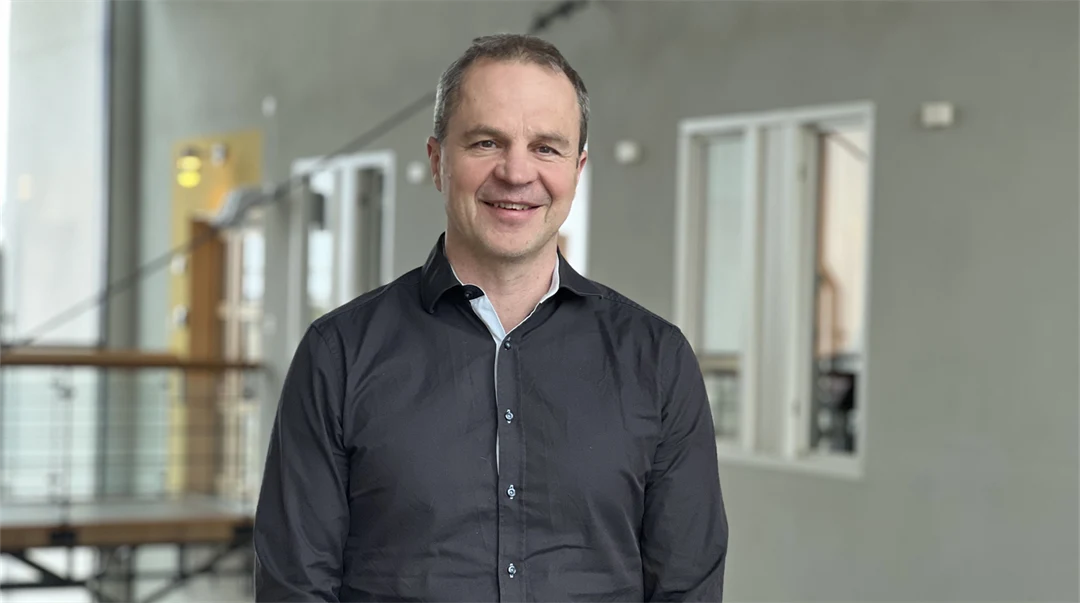 A man smiles and looks into the camera.