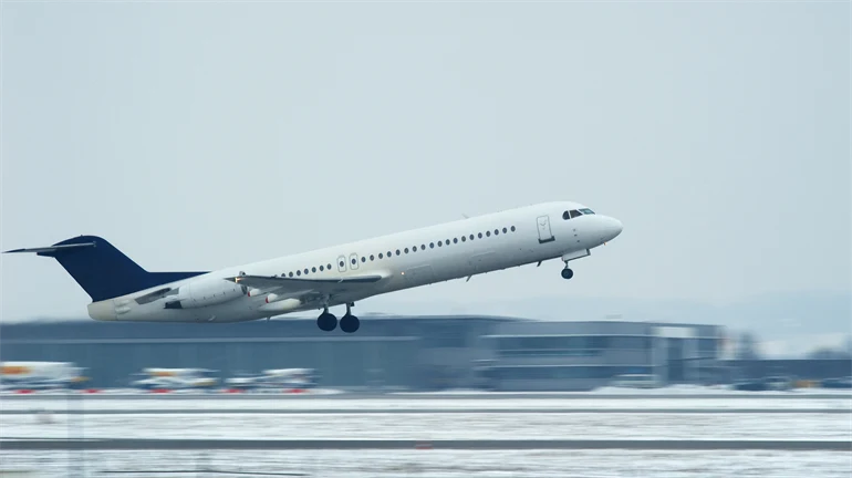 Flygplan på väg att lyfta från en vintrig flygplats.