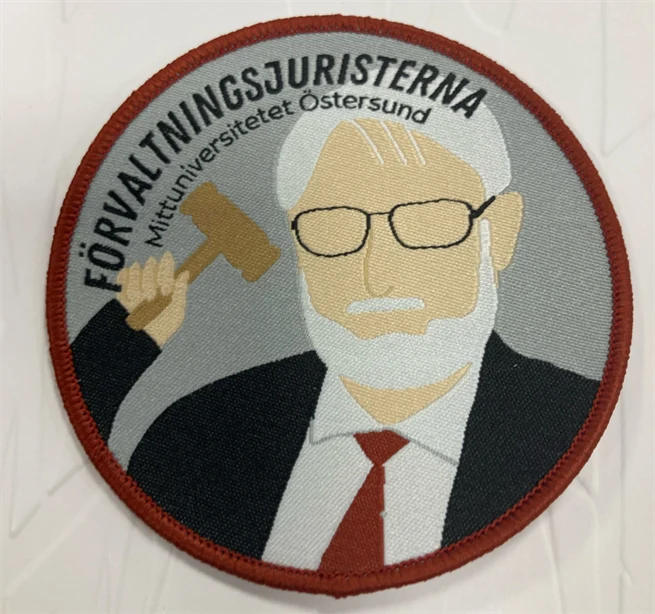 Tygmärke med bild på en manlig lärare