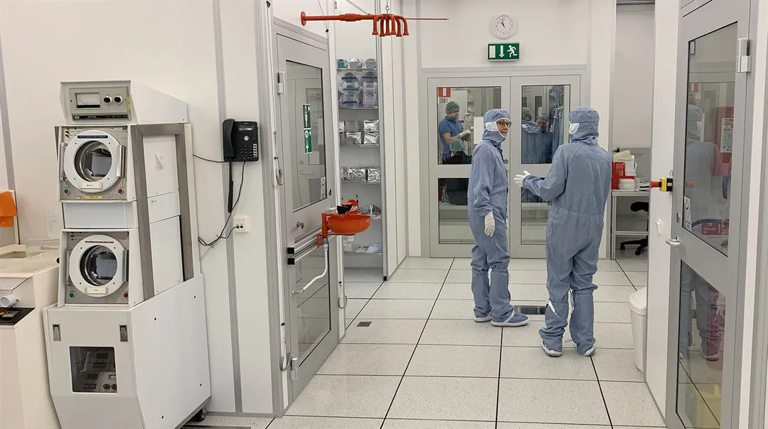 Two people standing in the Clean room, talking to each other.